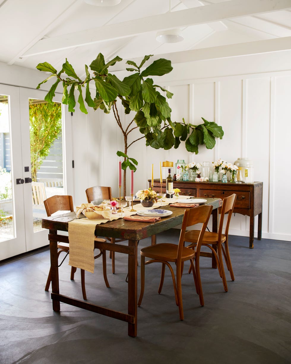 Curtis California dining room dining room with board and batten walls, vintage wood furniture, and a large fig tree