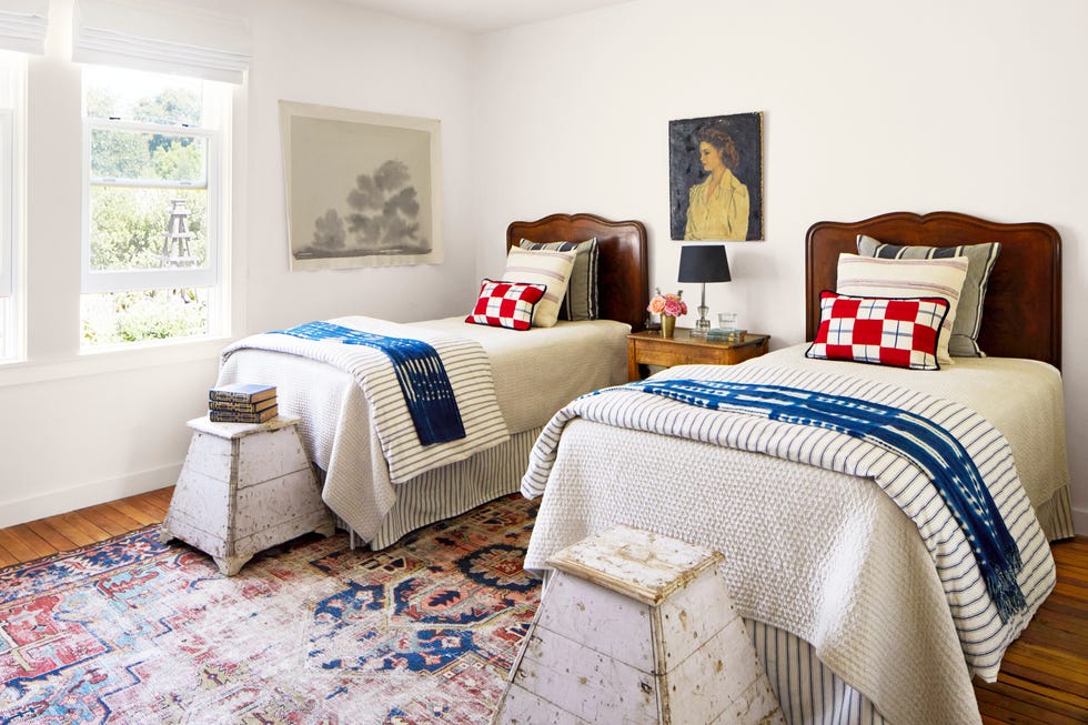 twin bed guest room bedroom with wood headboard twin beds and vintage blue, white, and red linens