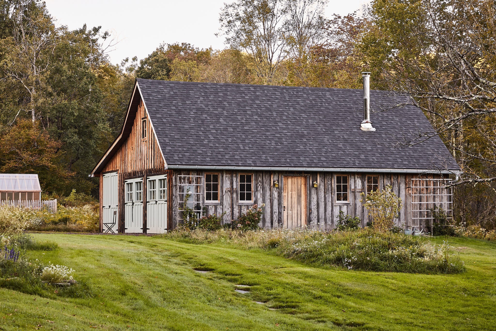 barn with wood siding surrounded by grass and wildflowers