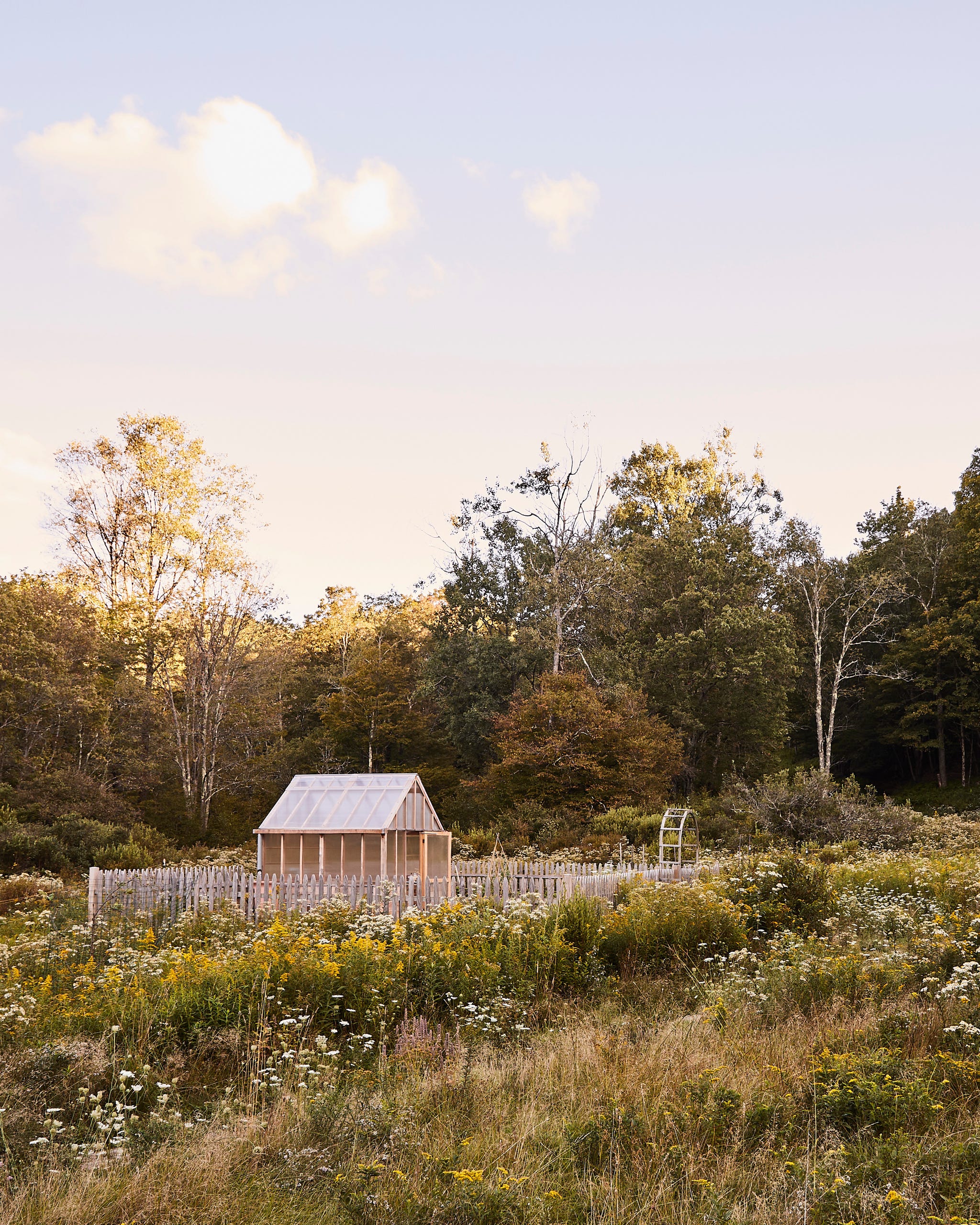 fenced in garden within a meadow of wildflowers