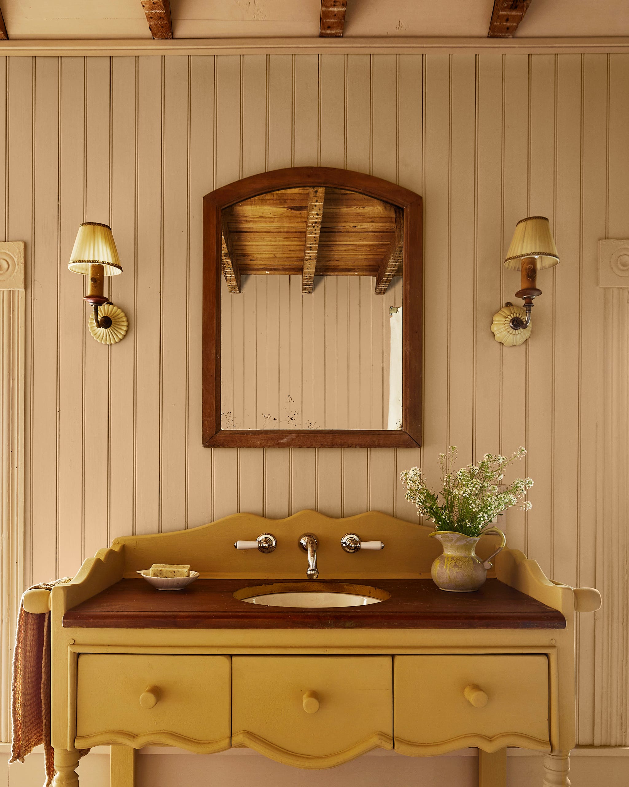 a vintagestyle bathroom sink with a yellow base and brown countertop