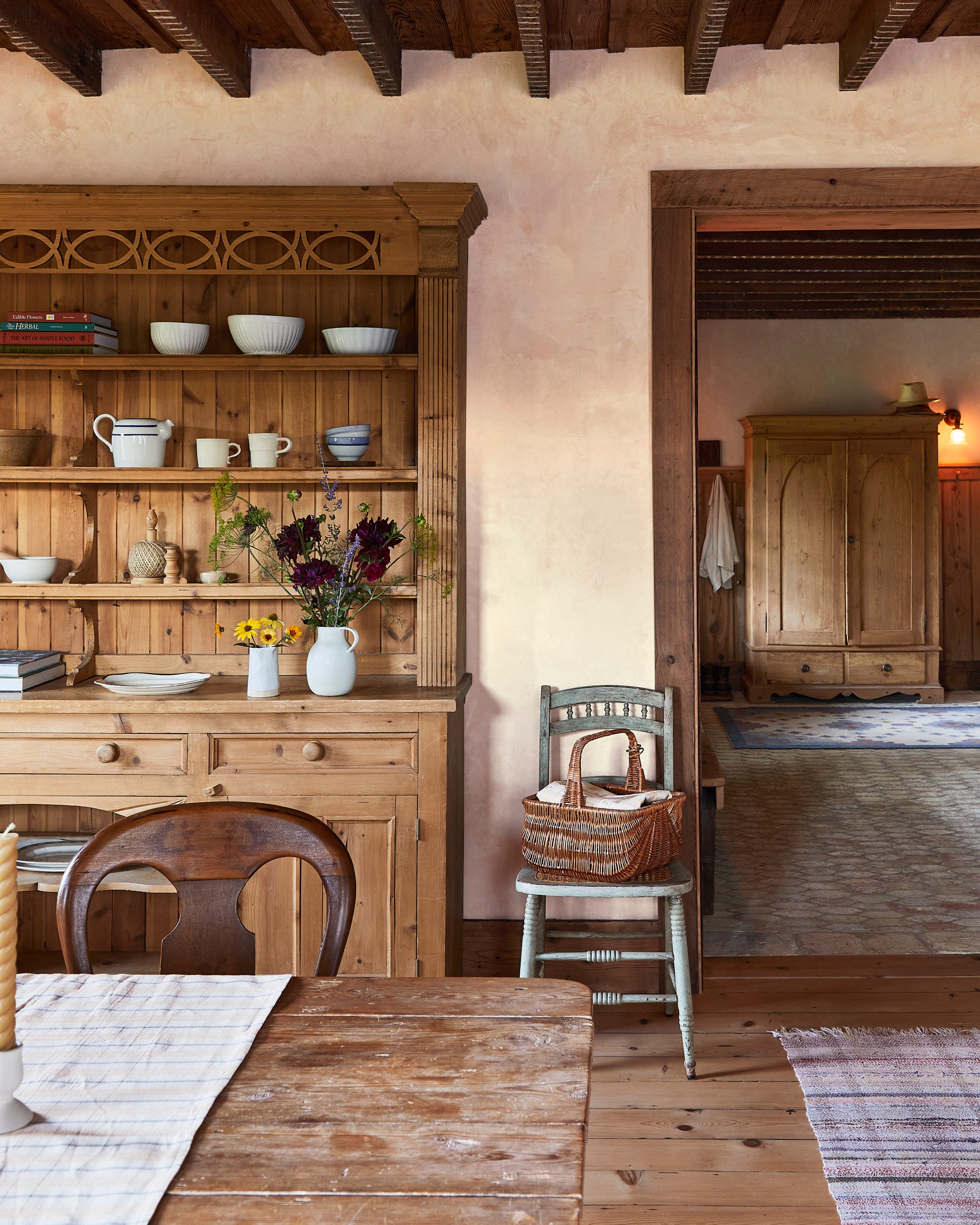 farmhouse kitchen with wood hutch with dishes on shelves and a table in front of it