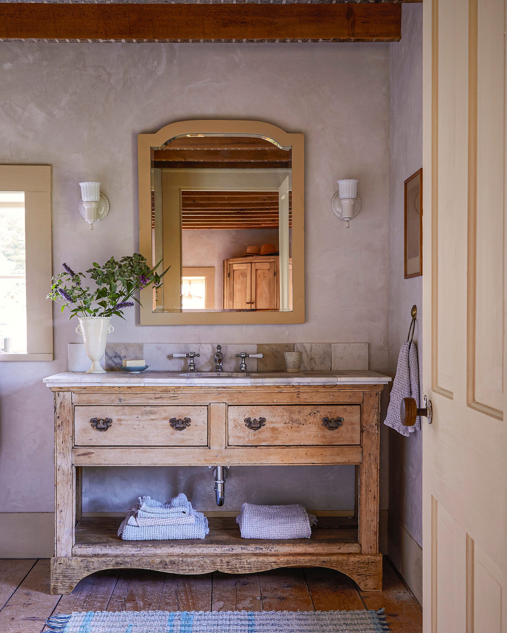 bathroom vanity with wood base and marble top with sink and hardwood floors beneath it