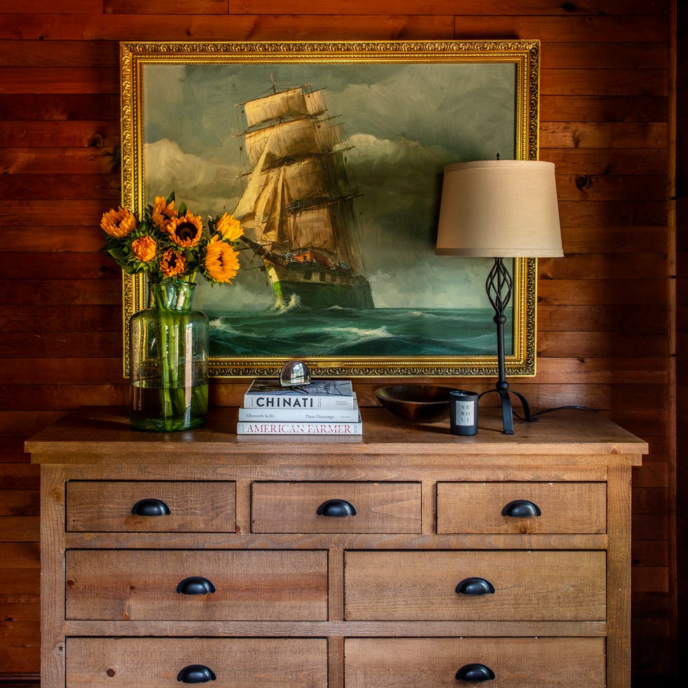 vintage ship painting above wood dresser