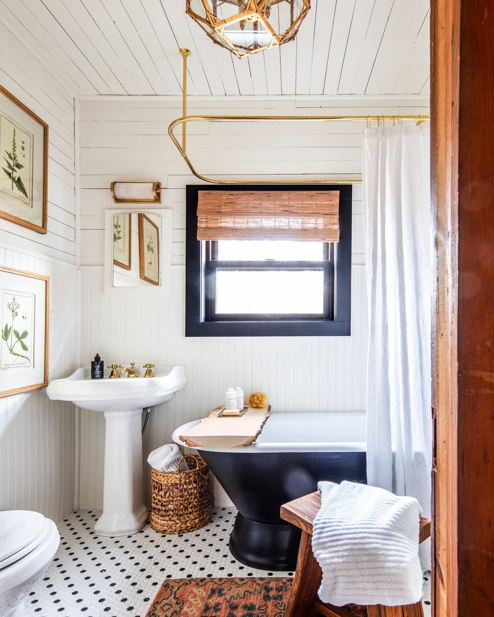 white farmhouse bathroom with pedestal sink and skirted tub