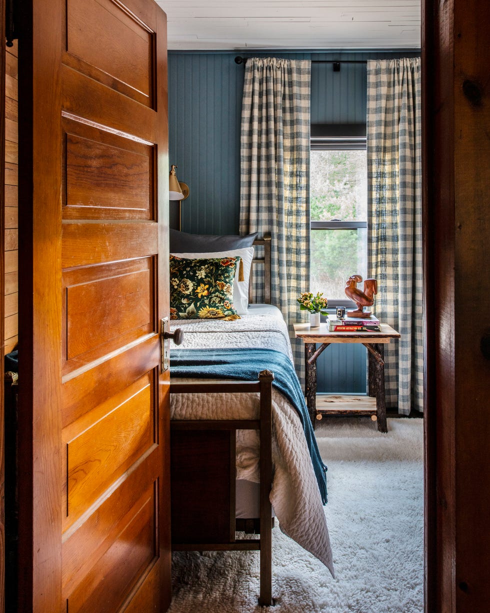 rustic farmhouse bedroom with blue beadboard walls and gingham curtains