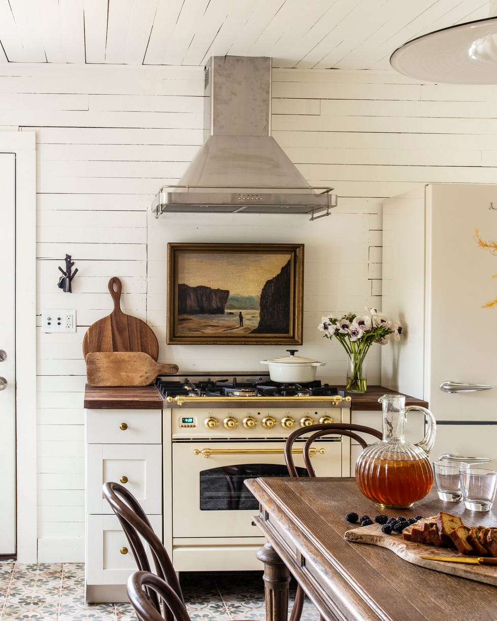 a white farmhouse kitchen with a table and chairs