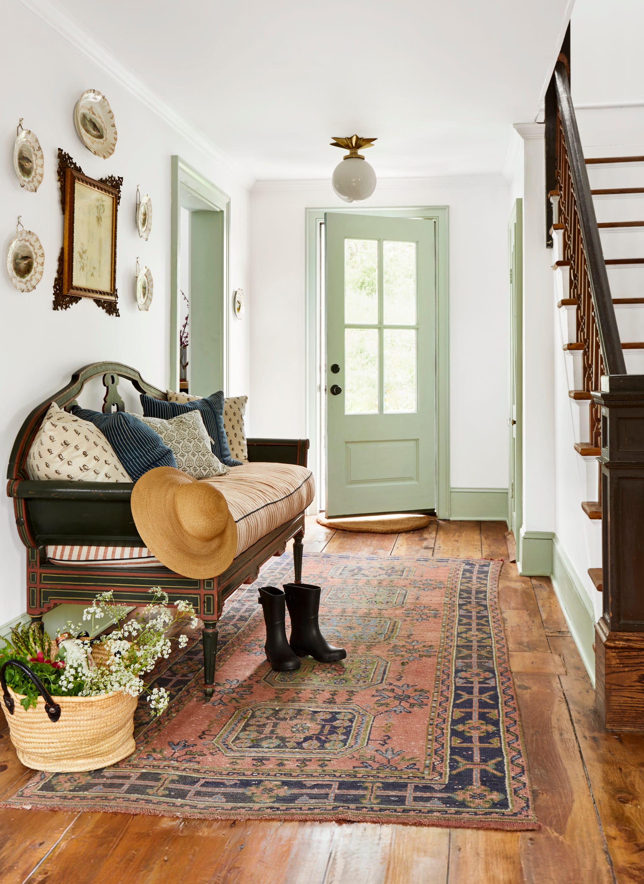 entryway featuring a decorative bench potted plants and a patterned rug as well as a staircase