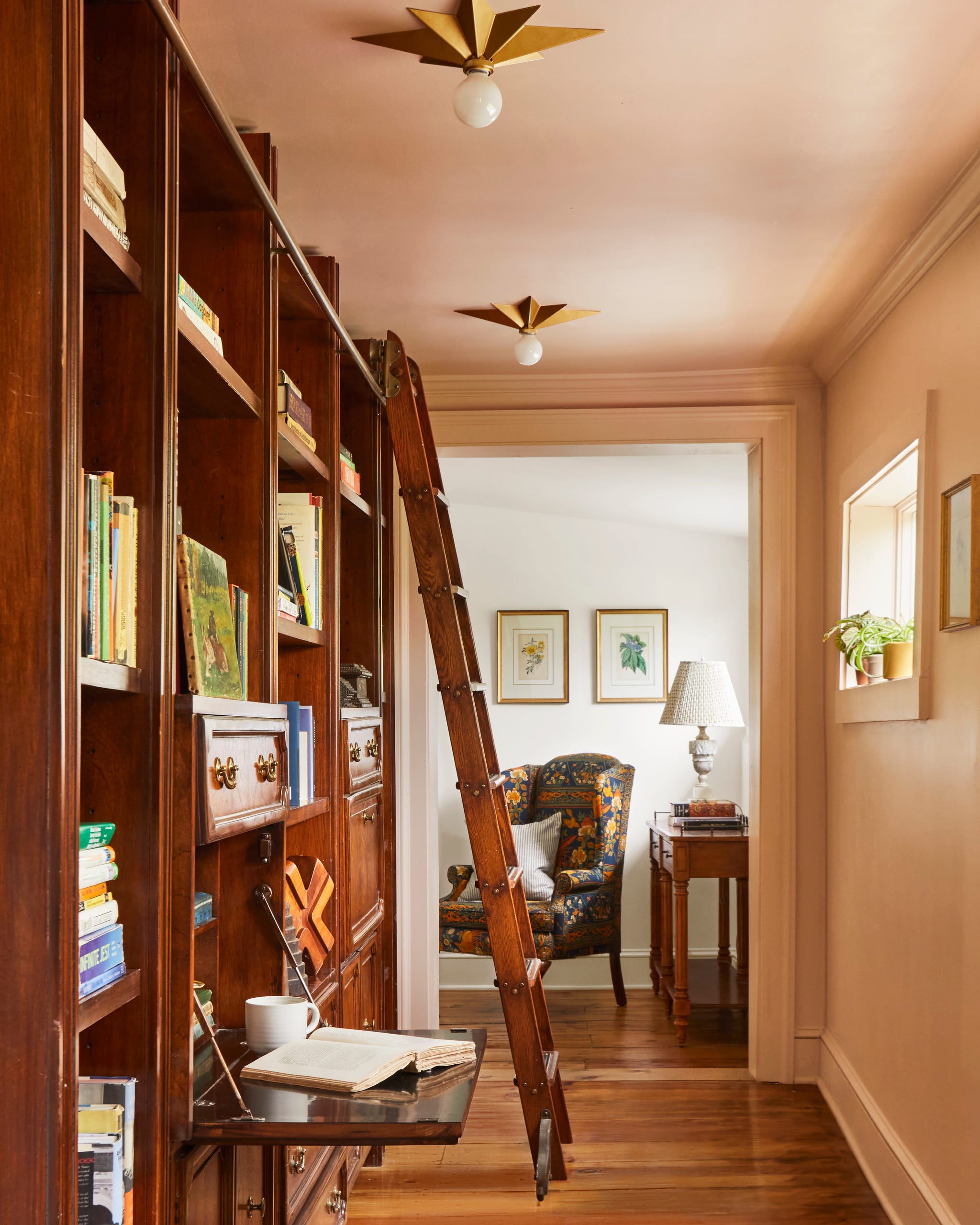 hallway with large bookcase and ladder