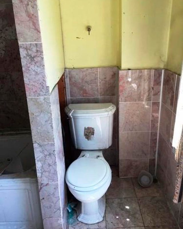 bathroom corner featuring a toilet and wall tiles